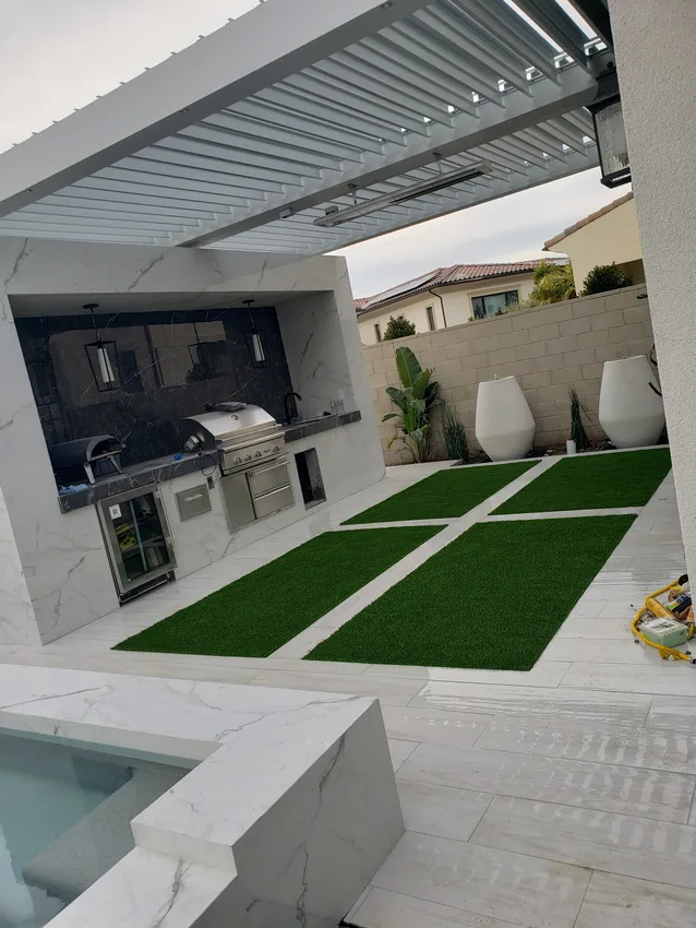 Rectangular artificial turf inlays within a paved outdoor living area